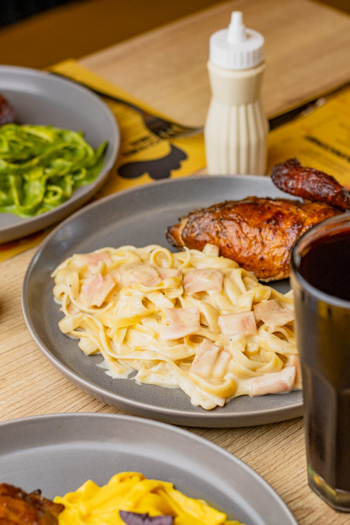 Savory Peruvian-style chicken served with creamy pasta and fresh sides in Tacna, Perú.
