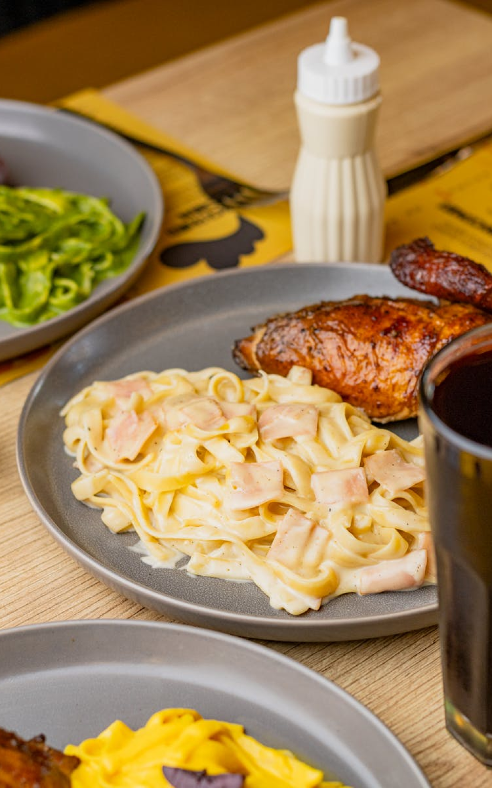 Savory Peruvian-style chicken served with creamy pasta and fresh sides in Tacna, Perú.